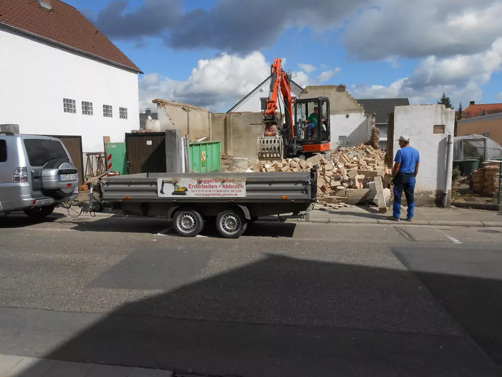 2 Bauarbeiter auf einer Baustelle bei Abbrucharbeiten eines Hauses