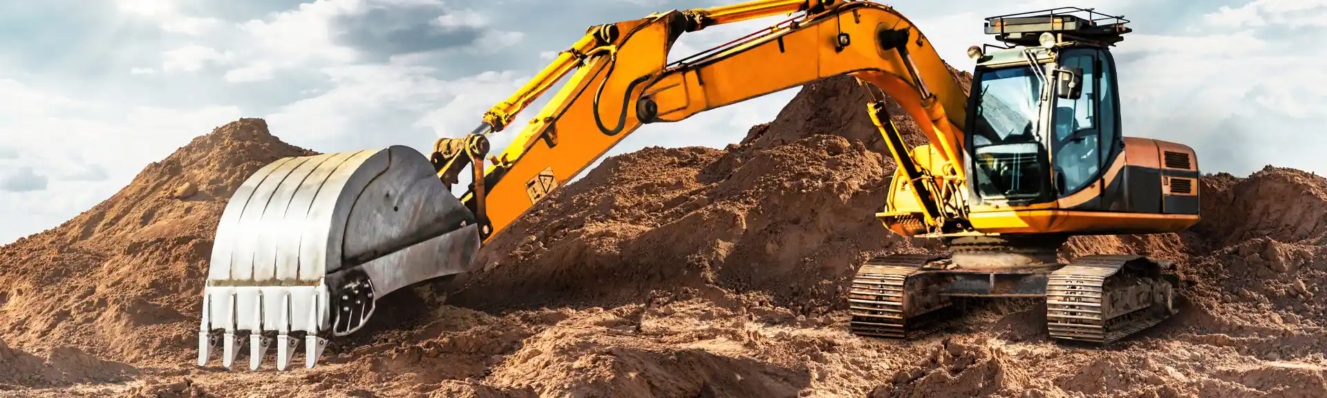 Bagger mit Schaufel gräbt auf einer Baustelle ein Loch