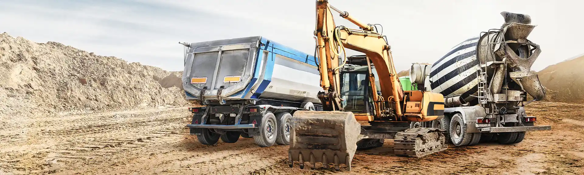 Baustellenfahrzeuge auf der Baustelle: Mischmaschine, Bagger, Lastwagen